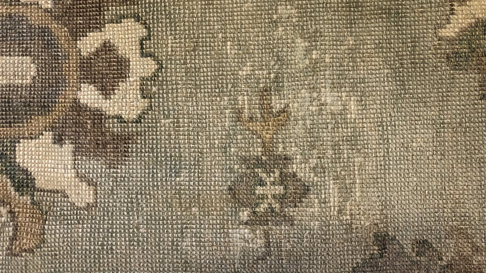 The reverse of a wool rug, where a shrunken cotton foundation shows before the pile gives it away